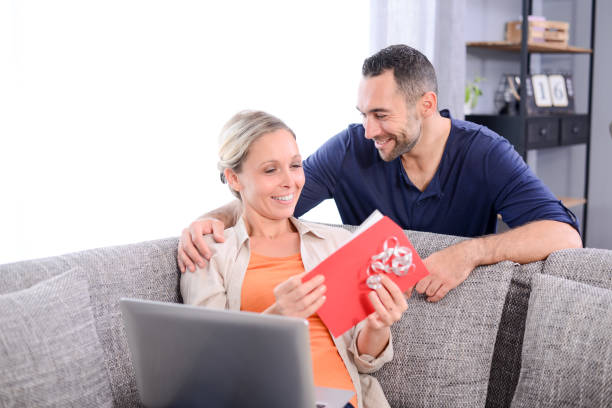 istock handsome man offering surprise present invitation in envelope gift to his young woman valentine girlfriend 942169766