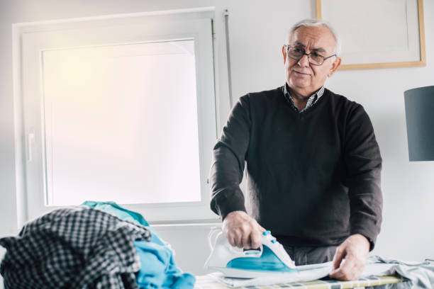 istock Concentrated mature man ironing the laundry at home 942175138