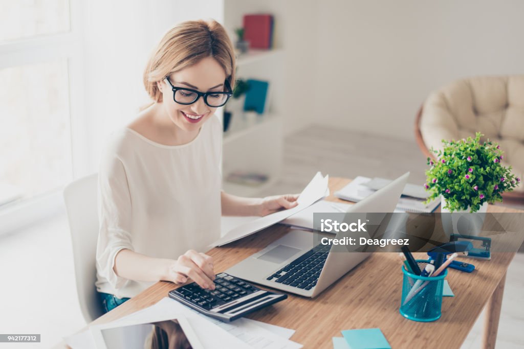 Happy cute  pretty accountant working with computer and calculator Financial Advisor Stock Photo