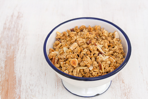 granola with nuts in the bowl on wooden background