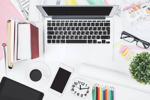 istock White desk with laptop and other items 942179164