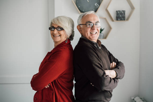 istock Happy mature couple standing back to back with their hands clasped 942179370