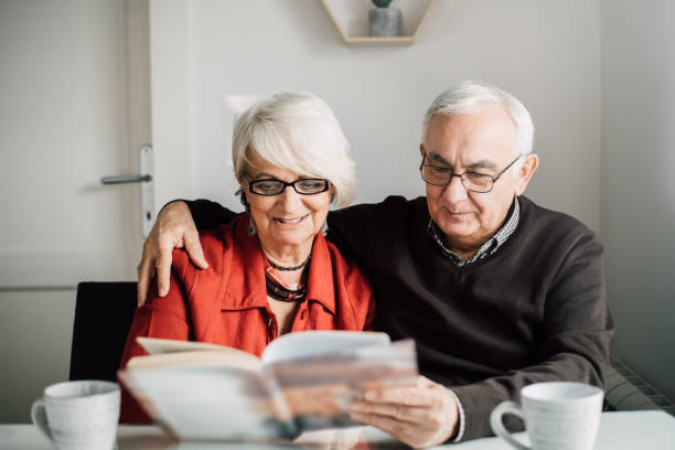 istock Older couple reading a book together 942181254