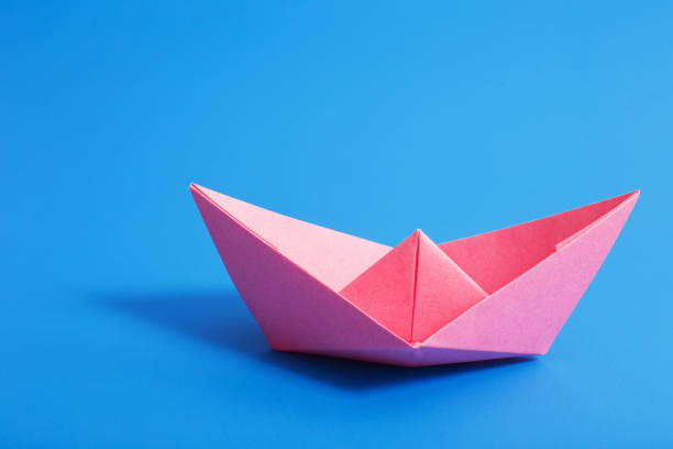 istock paper boat on blue paper background 942183640
