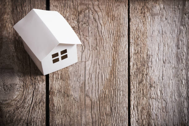 istock paper house on old wooden background 942183662