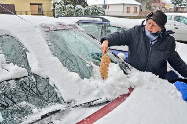 istock Woman driver cleans the snow from the car 942185546