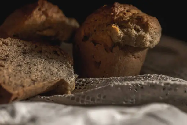 On old barn wood board and linen tablecloth, old-fashioned muffins.