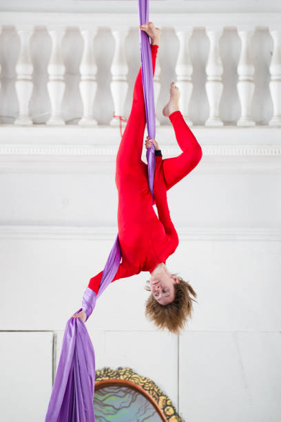 istock Young attractive woman hangs upside down on the aerial silk 942186848