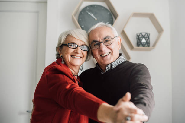 Older couple in love dancing at home