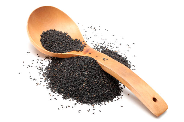 istock Black sesame in wooden spoon isolated on white background 942188690