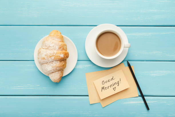 istock Cup of coffe and croissant on turquoise rustic table, top view 942189486
