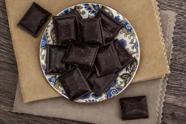 Dark Chocolate bars on napkins and brown wooden background