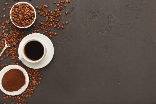 istock Cup of black coffee and scattered beans on gray background 942189742