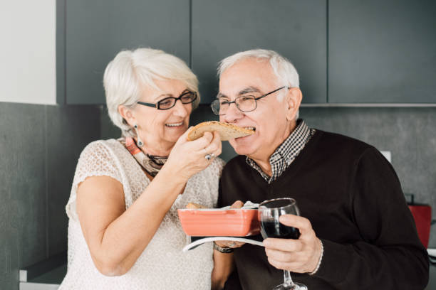 istock Senior couple in the kitchen tasting healthy seed bread 942190730
