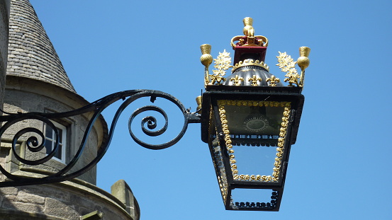 closeup of antique English style street lamp with gold colored decorations