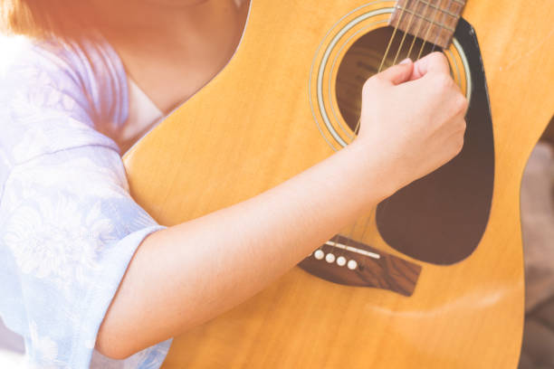 istock Young hipster woman playing a guitar. 942195900