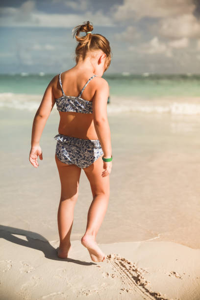 istock Little girl walks on sandy beach 942196544