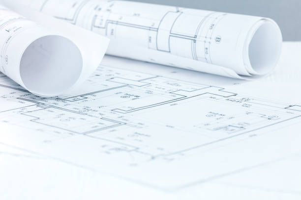 istock workplace of architect with technical project plans and blueprint rolls 942196892