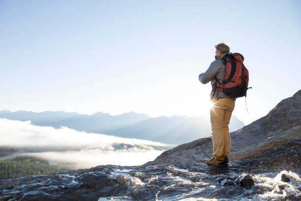 istock Mountaineer takes smart phone pic above mountains, sunrise 942201046