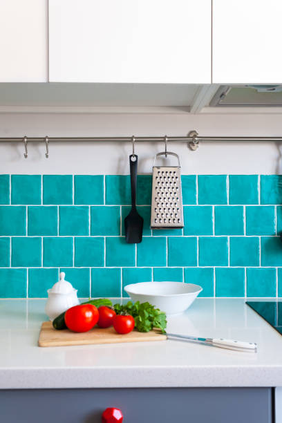 istock Kitchen features dark gray flat front cabinets paired with white quartz countertops and a glossy blue care tile. 942210320