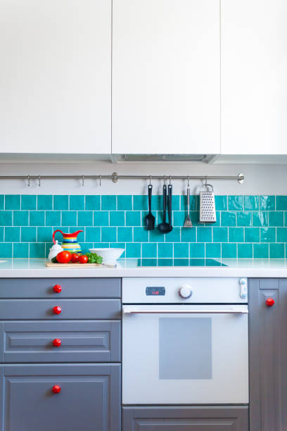 istock Kitchen features dark gray flat front cabinets paired with white quartz countertops and a glossy blue care tile. 942210322