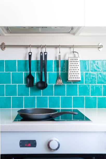 istock Kitchen features dark gray flat front cabinets paired with white quartz countertops and a glossy blue care tile. 942210328