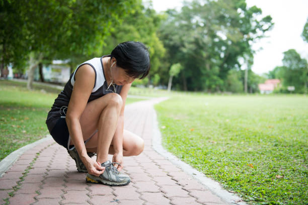 istock Senior jogger tighten her running shoe laces 942217088