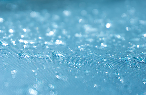 942217802 istock La lluvia cae sobre el fondo de cristal azul bokeh, brillantes gotas de lluvia sobre una superficie de vidrio, gotas de agua en un primer plano de la piscina 942217798