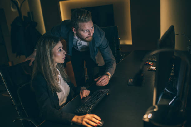 istock Business woman and man working late 942218106