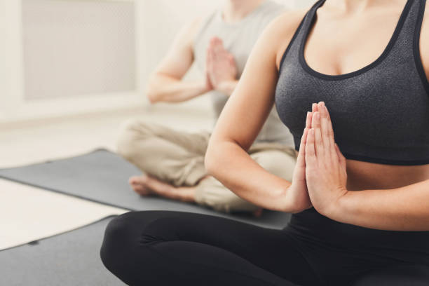 istock Young couple practicing yoga sitting in padmasana 942221474
