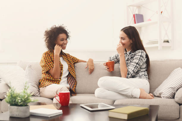istock Two young female friends with coffee conversing 942225336