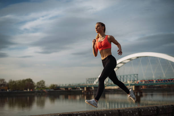 istock Young determined girl jogging near the river 942225470