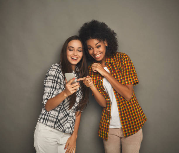 istock Two happy female friends using smartphone 942225668