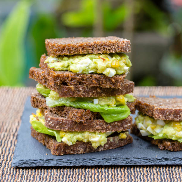 Sandwich with avocado and poached egg - healthy breakfast concept
