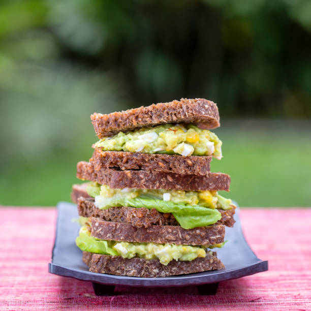 Sandwich with avocado and poached egg - healthy breakfast concept