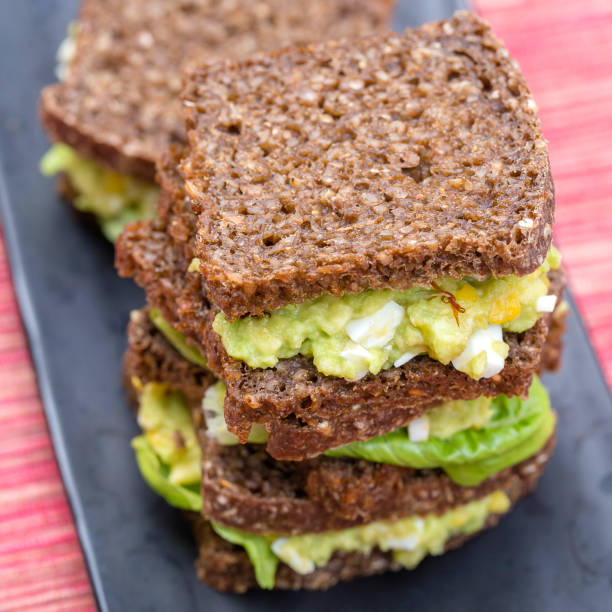 Sandwich with avocado and poached egg - healthy breakfast concept