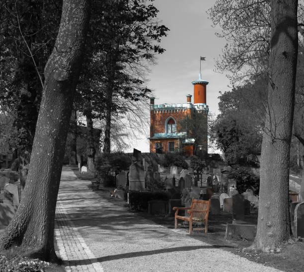 istock Little red castle and the bench at black and white cemetery 942230504