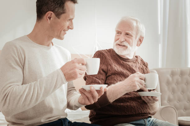 istock Satisfied sociable men smiling and drinking tea. 942234476