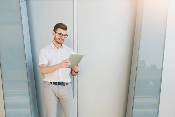 istock Young happy businessman using tablet outside 942234512