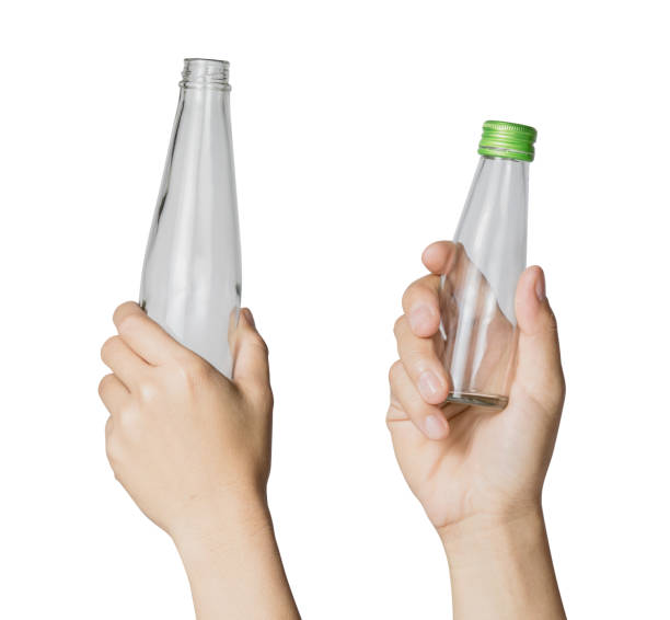 istock Woman's hand holding empty glass bottle transparent on white background, File contains a clipping path. 942234602