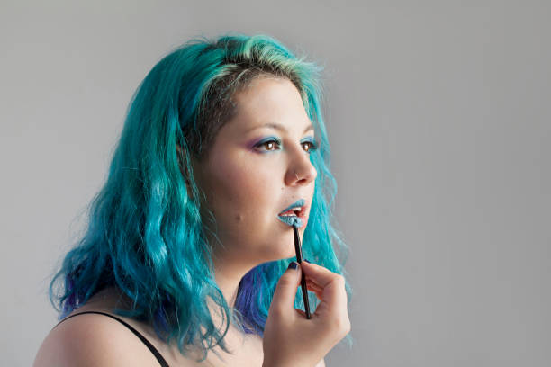 istock Woman applying lipstick 942237110