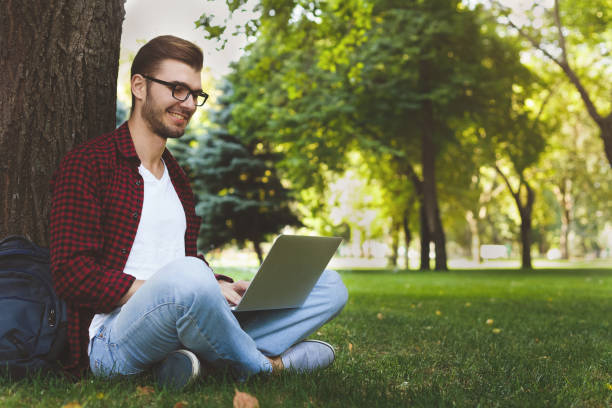 istock A smiling man with laptop outdoors 942237768