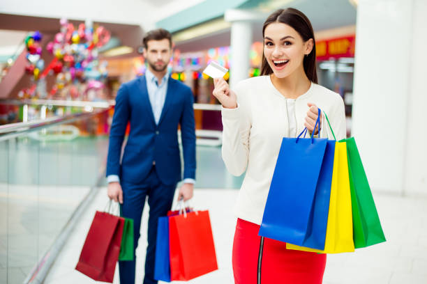 istock Attractive happy customers with packets and credit card after shopping 942238032