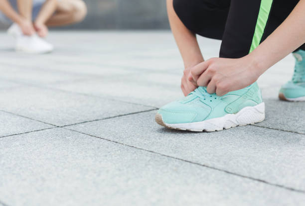 istock Unrecognizable man and woman tying shoelaces before running 942241000