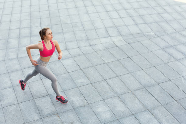 istock Young woman jogging in city copy space 942247468