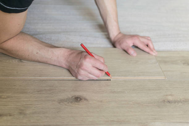 istock Carpenter worker installing laminate flooring in the room. 942250130