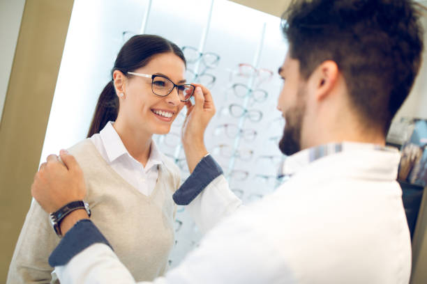 istock Young woman is selecting eyeglasses in optical store 942250172