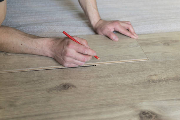 istock Carpenter worker installing laminate flooring in the room. 942251184