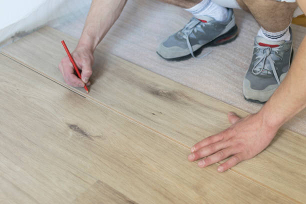 istock Carpenter worker installing laminate flooring in the room. 942255314