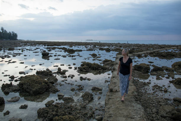 donna cammina da appartamenti di marea su sentiero al crepuscolo - 13417 foto e immagini stock